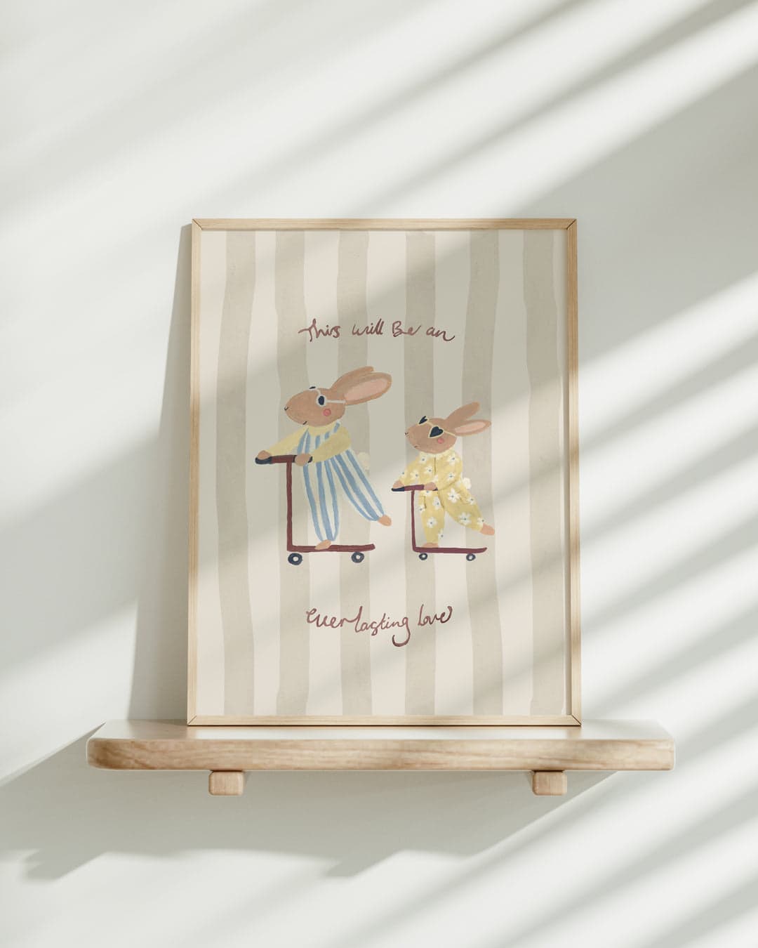 Lion & The Pear rabbits-on-scooters artwork displayed in a wooden frame